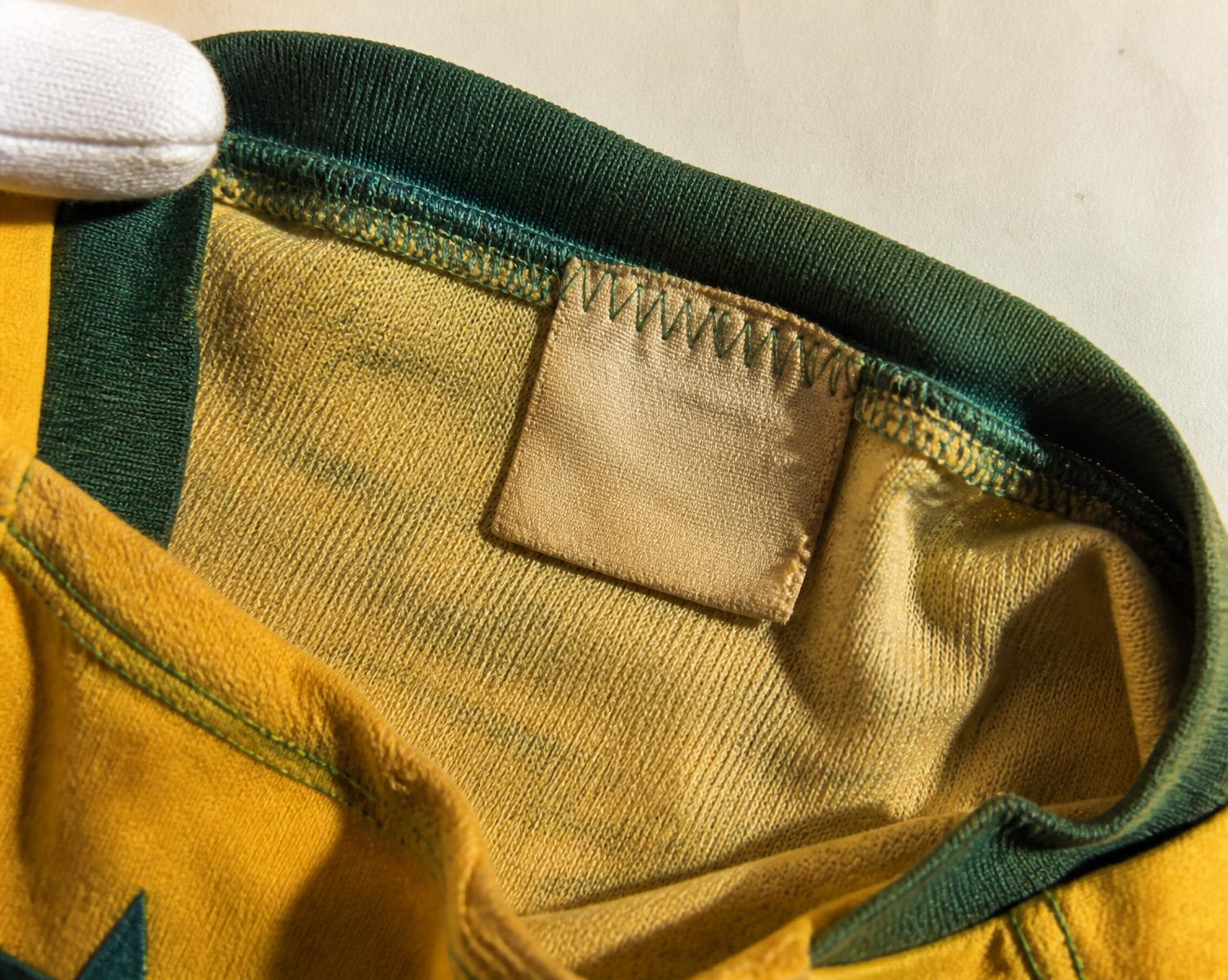 Detalhe macro da costura e etiqueta interna de uma camisa histórica de futebol